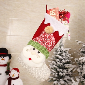 Detail of red Christmas stocking with 3D Santa applique and festive gift contents