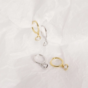 Macro shot of minimalist S925 sterling silver hoop earrings with round zircon pendants