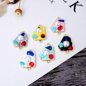 Detail of DIY jewelry connectors with gold borders, faux pearls and colorful crushed stones