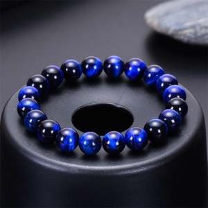 Macro detail of blue tiger eye stone beads with natural chatoyant texture on black stand
