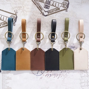 Vintage echt lederen sleutelhangers in zes kleuren met metalen ringen op retro papier