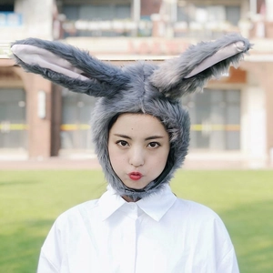 Cute grey plush bunny ear hat accessory being worn by a model in an outdoor setting