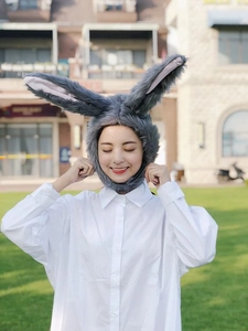 Detailed close-up of soft grey plush rabbit ears hat worn by a model in nature