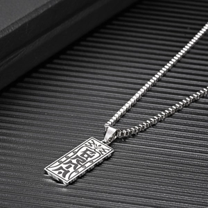 Detailed close-up of a silver stainless steel rectangular pendant with Taoist engravings