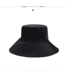 Detail of a black wide brim sun hat with reinforced stitching and flat top design