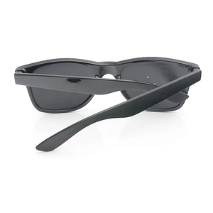 Rear view of folded black pinhole glasses with glossy plastic frames and curved temples
