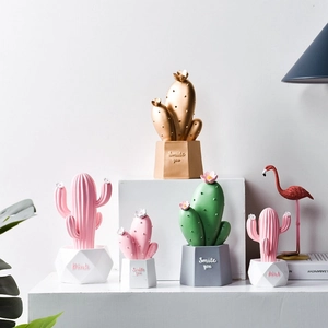 Nordic decorative resin cactus ornaments in pink, green and gold on white steps