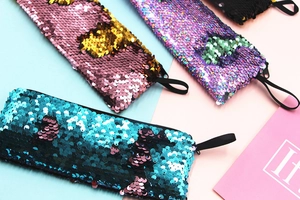 Flat lay of colorful mermaid reversible sequin stationery pouches with zippers