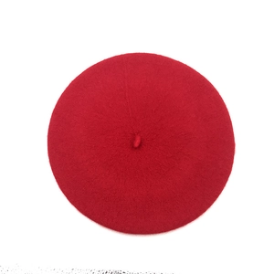 Top down view of red wool beret showing classic round shape and top stem detail