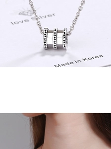 Macro shot of silver ring pendant with geometric patterns and sleek metallic finish