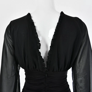 Detailed back view of a black deep V-neck dress featuring ruffle edges and sheer mesh sleeves