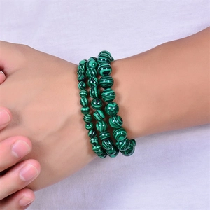 Close-up of a multi-layer green malachite beaded bracelet worn on a woman's wrist