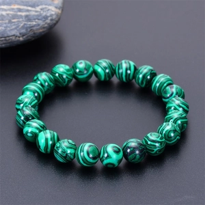 Detailed view of natural malachite beads showing green circular patterns and textures