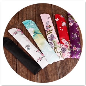 Set of 6 assorted floral silk sleeve pouches for chopsticks on dark wood background