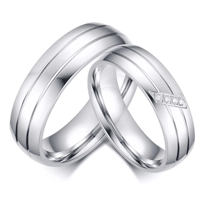 Macro detail of silver titanium steel couple rings with brushed finish and four diamonds