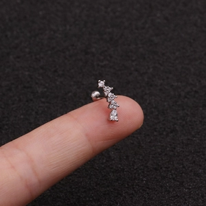 Silver drop zircon stainless steel screw earring on a fingertip close-up view