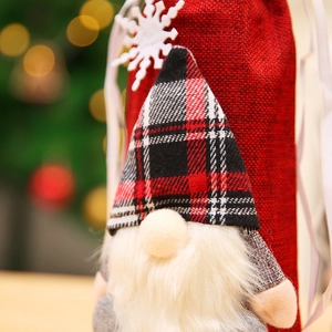 Detailed close-up of a festive Christmas wine bottle cover with a plaid gnome and snowflakes