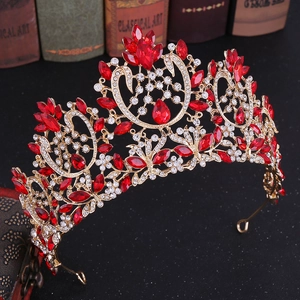 Close-up of gold baroque bridal crown with red crystals and intricate floral details