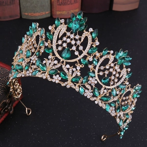 Detail of luxury Baroque bridal crown with green gems and gold base on vintage background