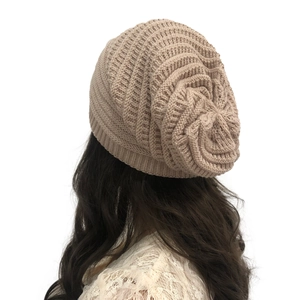 Rear view of khaki knitted beanie showing twill weave pattern and slouchy fit on model