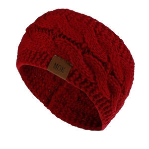 Detailed cable knit texture of dark red winter headband with a brown leather label