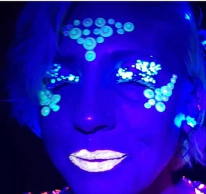 Glow-in-the-dark self-adhesive face jewels showing luminous green effect under UV light