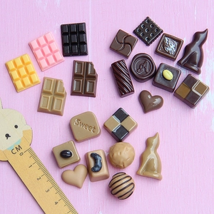 Macro view of assorted mini resin chocolates with ruler for size scale reference