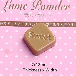 Macro shot of a square brown resin chocolate charm with Sweet engraving for DIY crafts