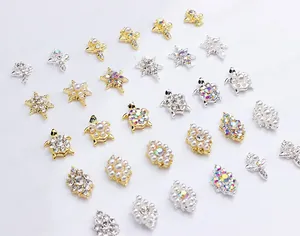 Macro shot of assorted alloy nail art charms featuring sunflowers and turtles with pearls