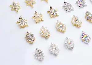 Macro detail of alloy nail charms with sun flowers, turtles and rhinestones for DIY art