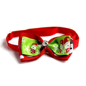 Detail of festive pet bowtie with green snowman pattern and sparkling crystal center