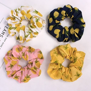 Set of four pineapple pattern scrunchies in white, navy, pink, and yellow fabric