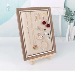 Detail view of wooden jewelry display board with linen lining for earrings and necklaces