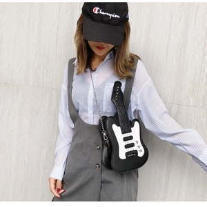 Detailed view of guitar-shaped crossbody bag with contrast colors and star accents on model