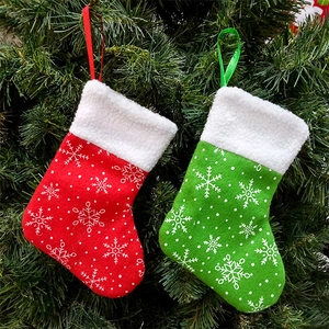 Christmas stocking gift bags with snowflake patterns hanging on a lush green Xmas tree