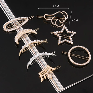 Detail view of pearl and rhinestone hairpins in moon, star, and crown shapes