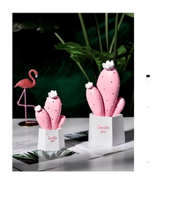 Detail of pink resin cactus ornaments with Smile You inscription on white pots