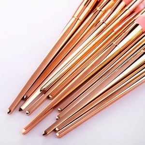 Detailed close-up of rose gold makeup brushes with tapered handles and pink soft bristles