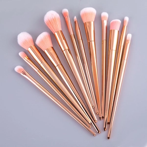 Detail of 12pcs rose gold makeup brushes with pink-white gradient bristles on gray background