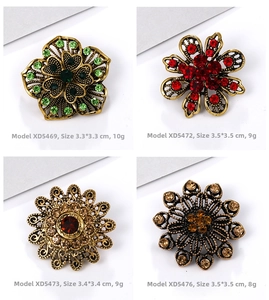 Detailed macro view of four vintage flower brooches with colorful rhinestones in gold