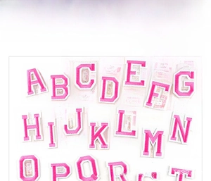 Detail of rose red and orange embroidered alphabet patches with white border and heat seal back