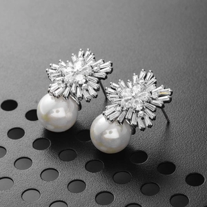 Elegant 925 silver snowflake earrings with cubic zirconia and white pearls on black backdrop