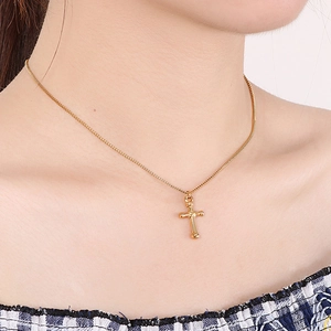 Elegant gold titanium steel cross necklace for women worn on a model's neck