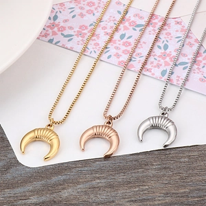 Three crescent moon pendant necklaces in gold, rose gold, and silver finishes on box chains