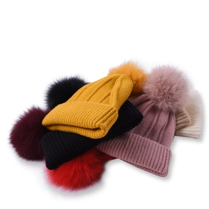 Chunky knit beanies with large fox fur pom poms in multiple colors for winter warmth