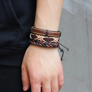 Three-piece leather bracelet set for men featuring braided and flat straps in brown and black