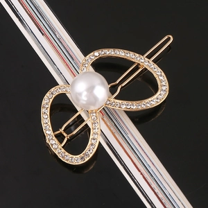 Detail of elegant gold hairpin with crystal infinity loops and white pearl accent
