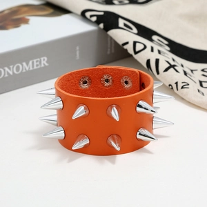 Close-up of orange punk leather bracelet featuring double-row silver metal cone studs