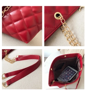 Detail view of red quilted shoulder bag showing metal chains and spacious interior