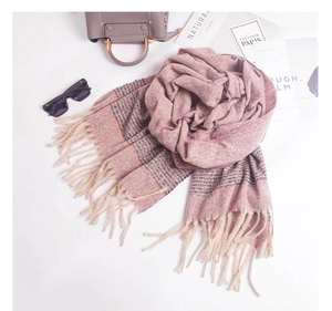 Close-up of pink and purple striped scarf with fringe detail and autumn lifestyle props